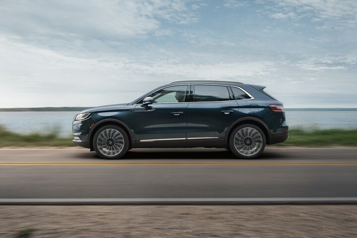 Se muestra una SUV Lincoln Black Label Nautilus® 2023 andando cerca de un lago