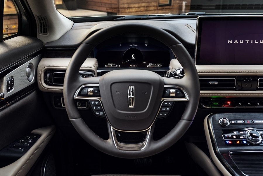 La pantalla de 12.3 pulgadas del conductor detrás del volante de una SUV Lincoln Nautilus® 2023 muestra la información de viaje