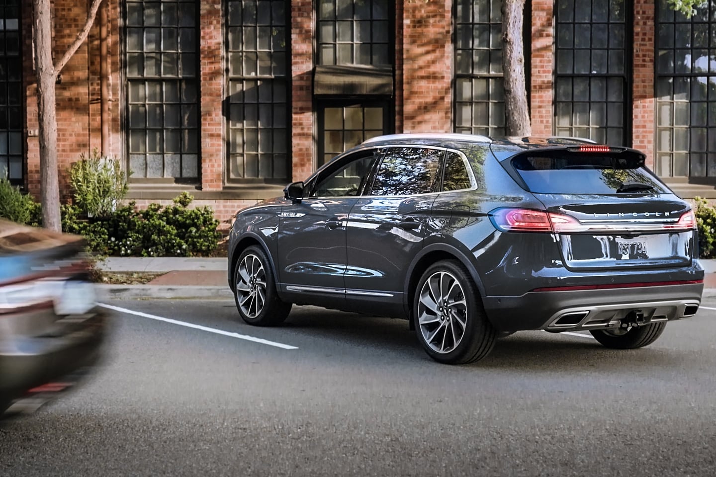 A 2023 Lincoln Nautilus® SUV is being backed out of a diagonal parking space while blind spot detection guides the driver