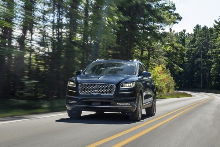 Una SUV Lincoln Black Label Nautilus® 2023 andando por un camino rural