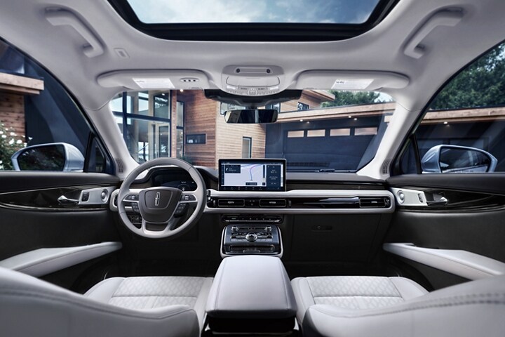 Se muestra una vista interior del área delantera de una SUV Lincoln Black Label Nautilus® 2023 con el tema Chalet