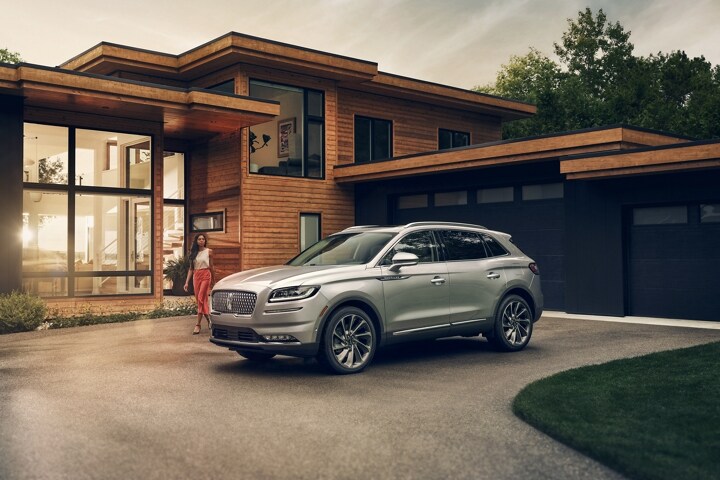 Una mujer se acerca a una SUV Lincoln Nautilus® 2023 en plateado radiante
