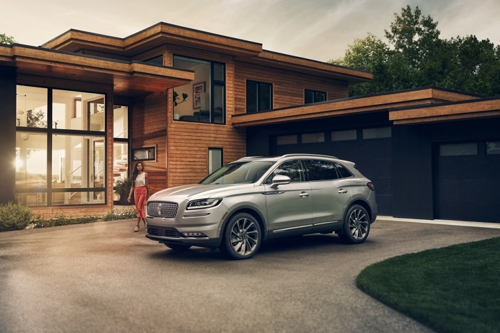 A woman is approaching a 2023 Lincoln Nautilus® SUV in Silver Radiance