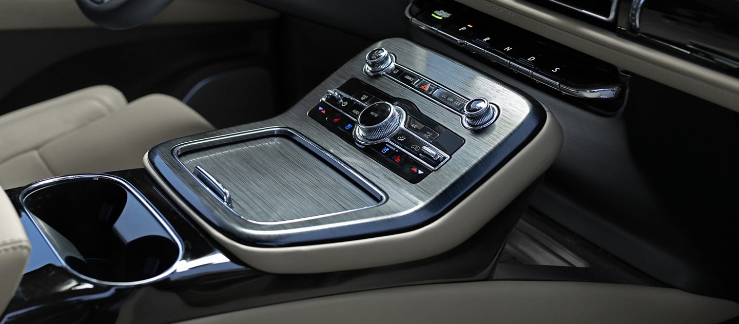 Se muestra la cabina delantera de una SUV Lincoln Nautilus® 2023 con controles intuitivos para el conductor y almacenamiento conveniente