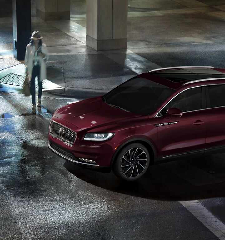 Pedestrians use a crosswalk in front of a 2023 Lincoln Nautilus® SUV