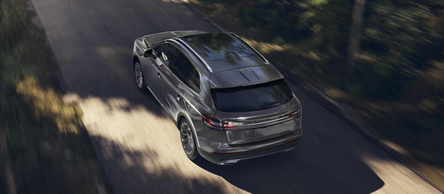 Se muestra una SUV Lincoln Nautilus® 2023 en una carretera bordeada de árboles para demostrar el rendimiento del motor doble turbocargado​​​​​​​.