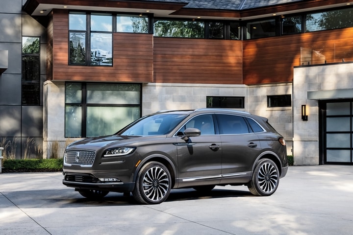 Una SUV Lincoln Black Label Nautilus® 2023 estacionada en frente de una casa moderna