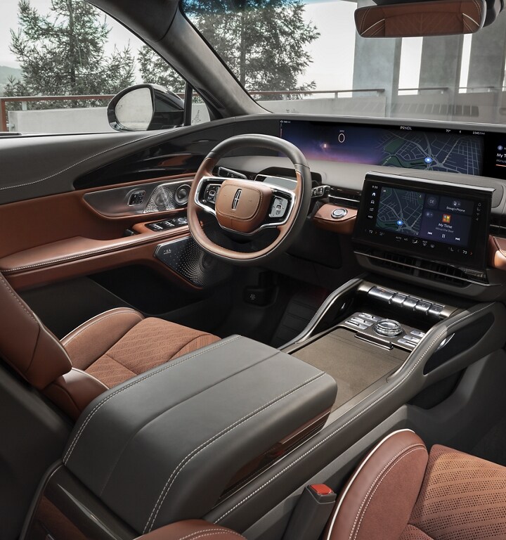 The interior of a 2024 Lincoln Black Label Nautilus® SUV showing the coast-to-coast display and Redwood interior theme.