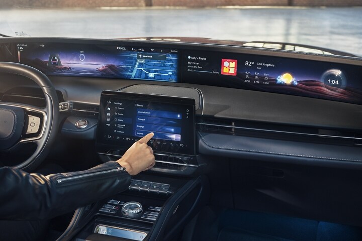 The driver of a parked 2025 Lincoln Nautilus® SUV adjusts the display theme that appears in the panoramic display