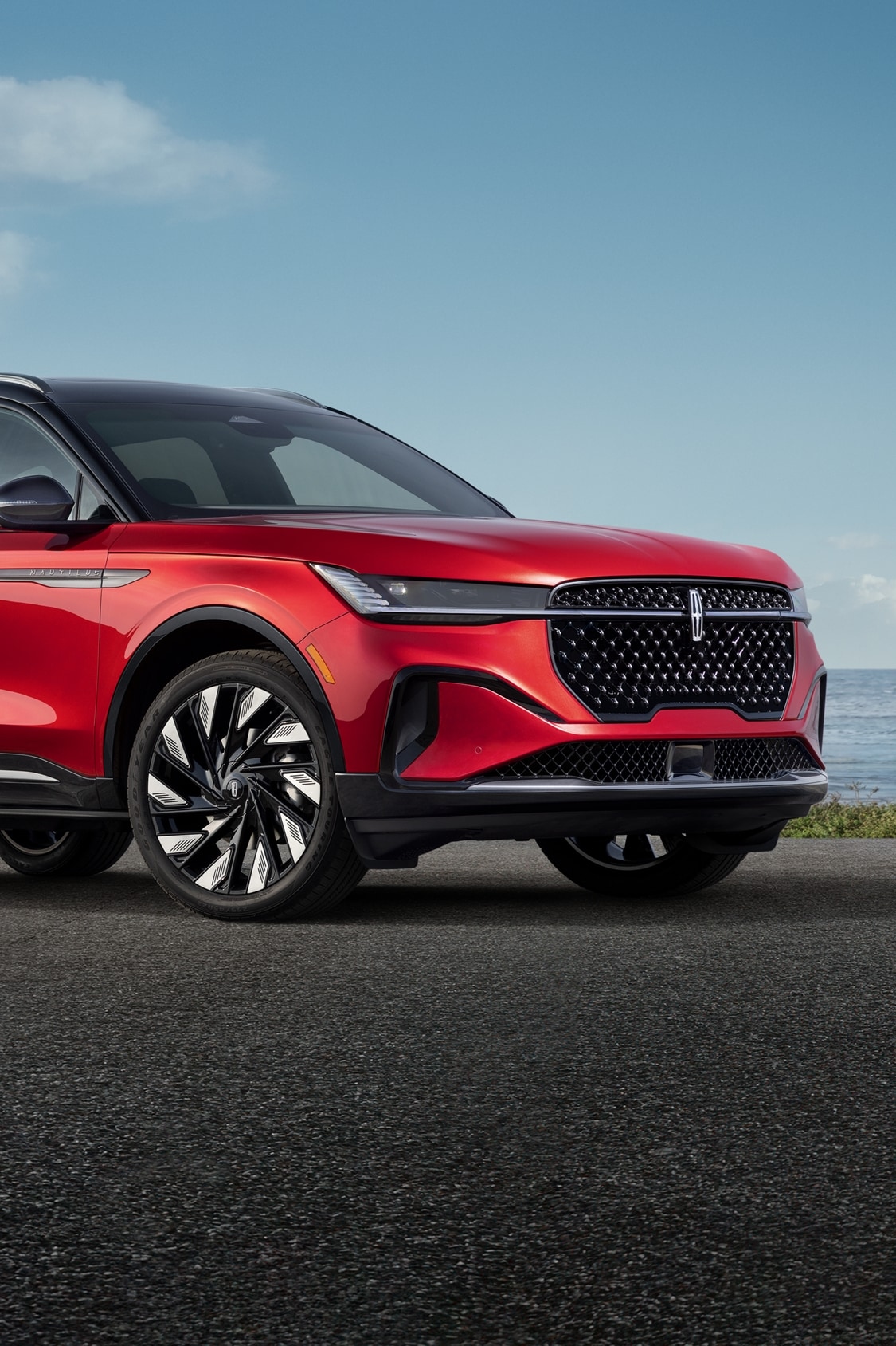A 2025 Lincoln Nautilus® SUV with the available Jet Appearance Package is parked on a seaside overlook