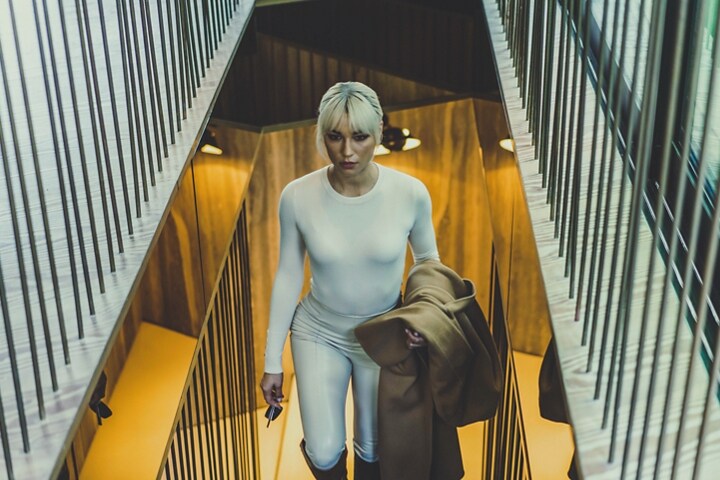 A person is shown ascending a staircase in a winter retreat