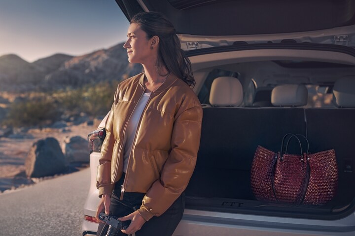 A person is seated on the back of a 2026 Lincoln Nautilus® SUV with the liftgate open