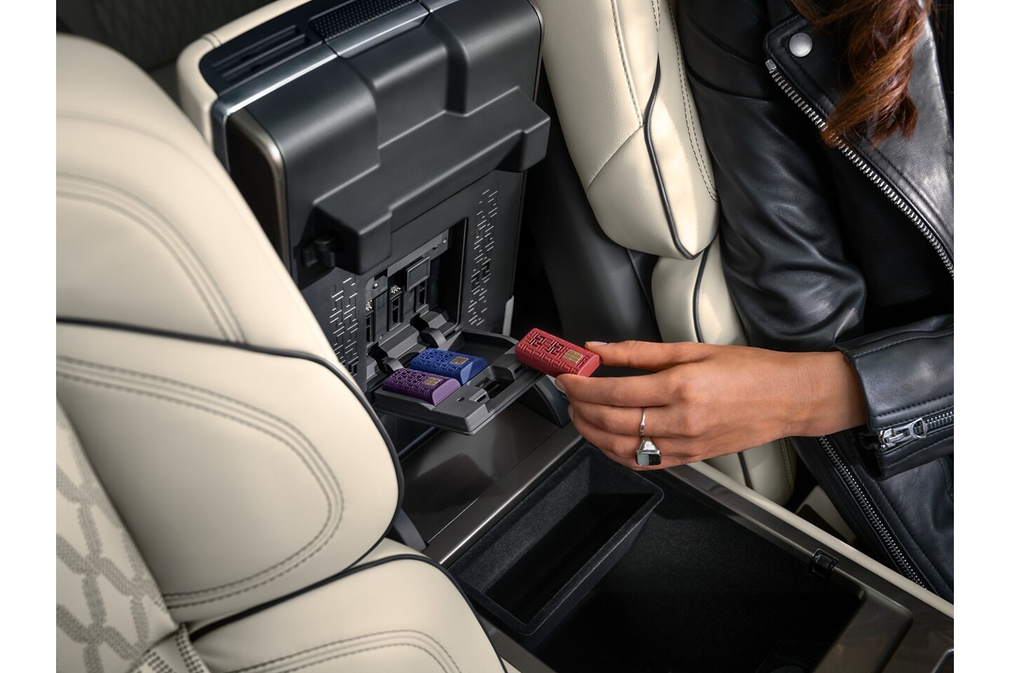 A person inserts a scent cartridge in the underside of the arm rest in a 2026 Lincoln Nautilus® SUV