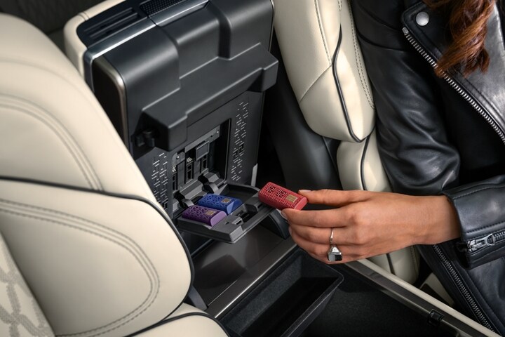 A person inserts a scent cartridge in the underside of the arm rest in a 2026 Lincoln Nautilus® SUV