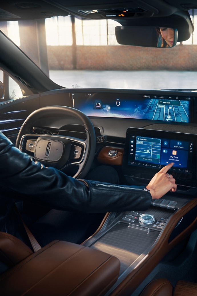 A woman interacts with the center touchscreen of a 2026 Lincoln Nautilus® SUV