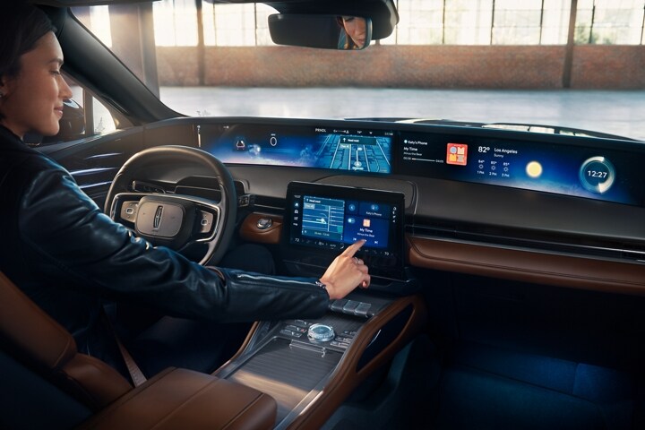 A woman interacts with the center touchscreen of a 2026 Lincoln Nautilus® SUV