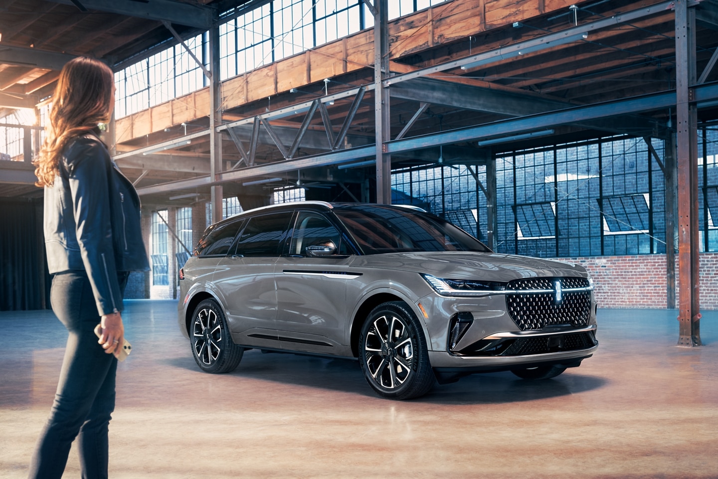 A woman approaches a 2026 Lincoln Nautilus® SUV while holding a mobile phone