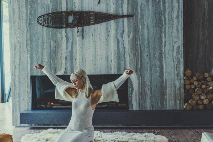 A woman stretches after a nice rest in a mountain chalet