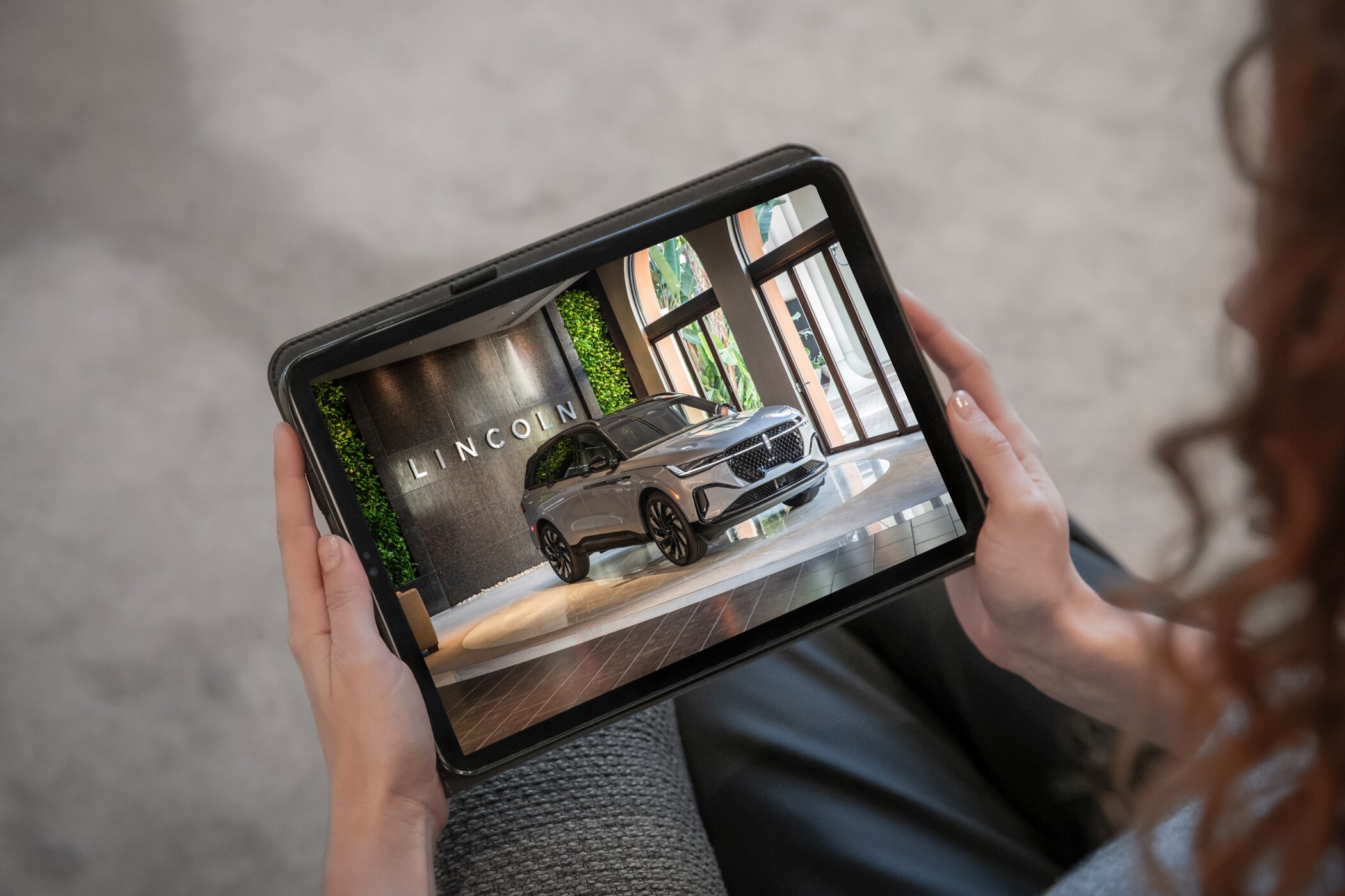 A person uses a mobile device to take a live tour of a Lincoln SUV