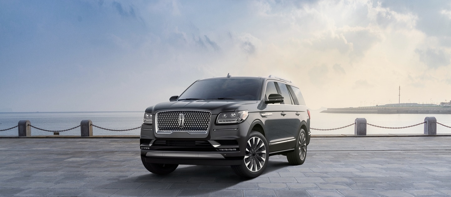 A 2021 Lincoln Navigator Reserve in Asher Gray is parked in front of a pier.