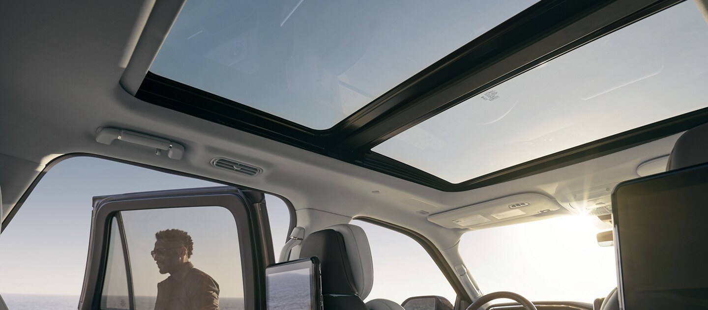Una imagen de un cielo celeste que se ve a través del enorme techo panorámico Vista Roof®, con el sol iluminando la amplia cabina con su calidez.