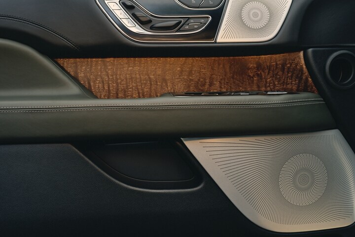 The inner door panel of a 2023 Lincoln Black Label Navigator® SUV shows the Revel® speaker design.