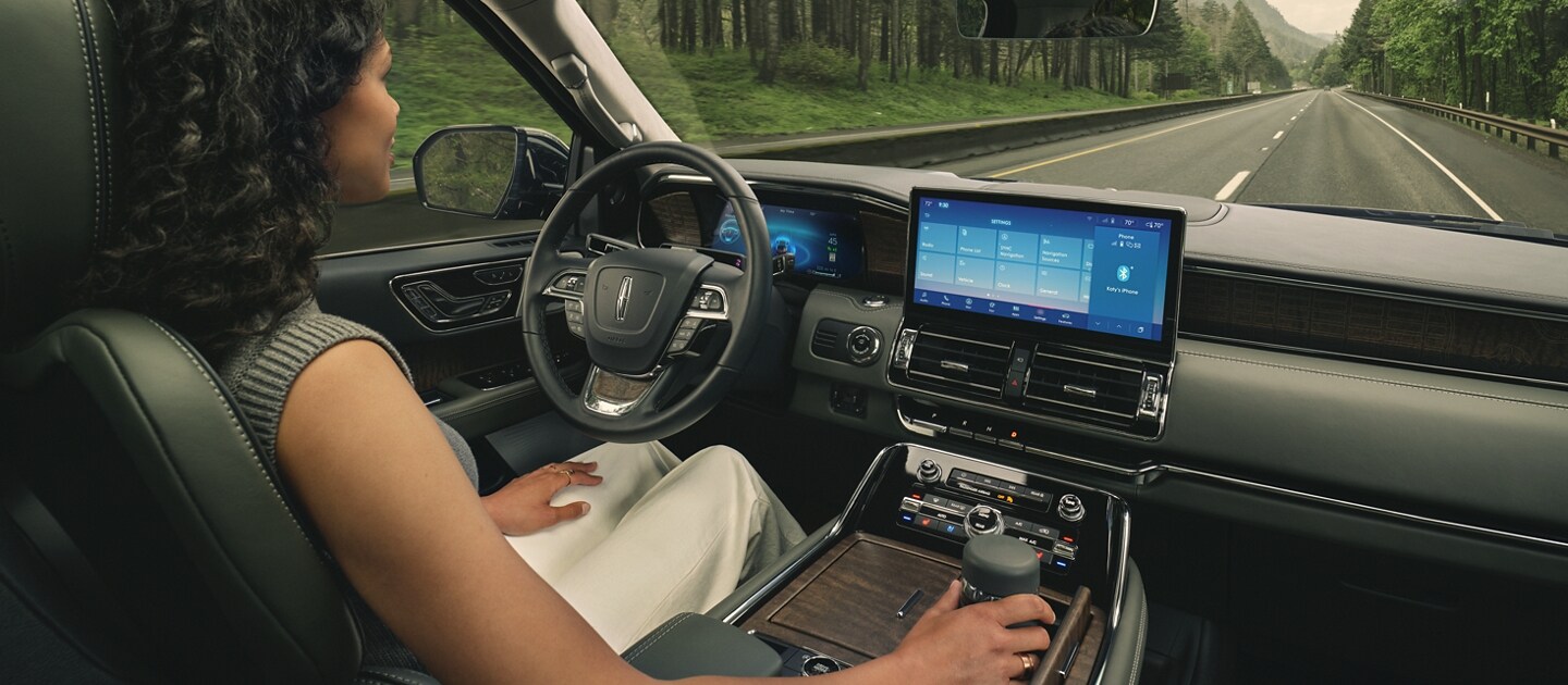 El conductor de una SUV Lincoln Black Label Navigator® 2023 se relaja con la tecnología de manejo manos libre activada