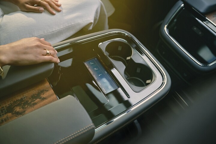 The rear digital touchscreen display and controls are cleanly integrated into the second-row console.