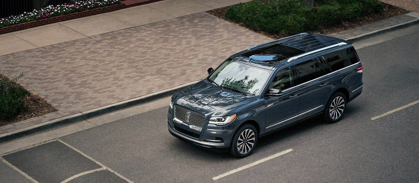 A 2023 Lincoln Navigator® SUV is being driven toward a speed bump on a downtown street.