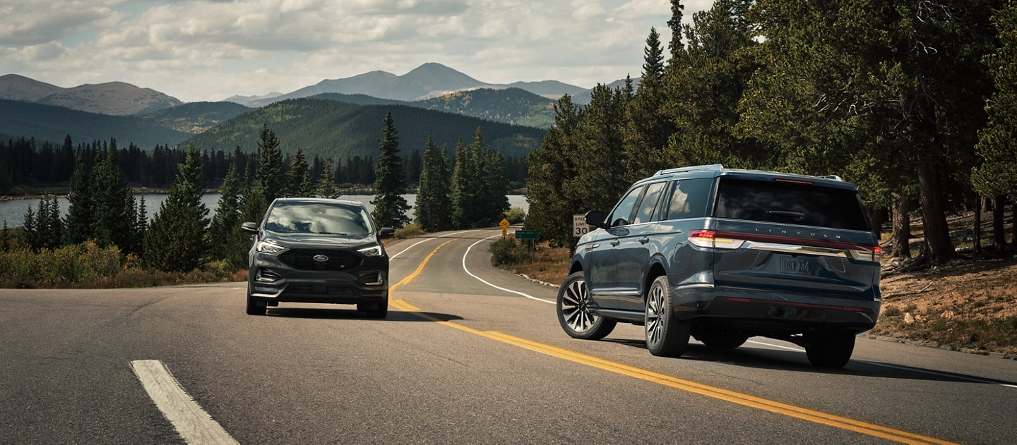 Una SUV Lincoln Navigator® 2023 gira a la izquierda cuando otro vehículo se acerca desde el otro carril.
