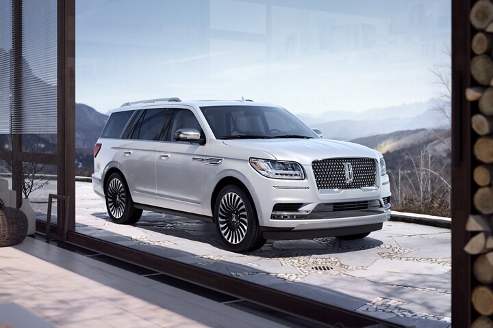 Una SUV Lincoln Black Label Navigator® 2023 en Chalet estacionada cerca de una montaña nevada.