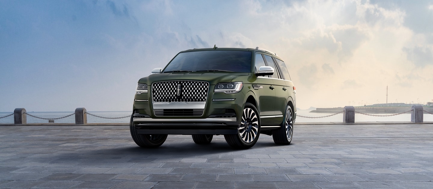 A 2023 Lincoln Black Label Navigator® SUV in Manhattan Green is parked by a bay.