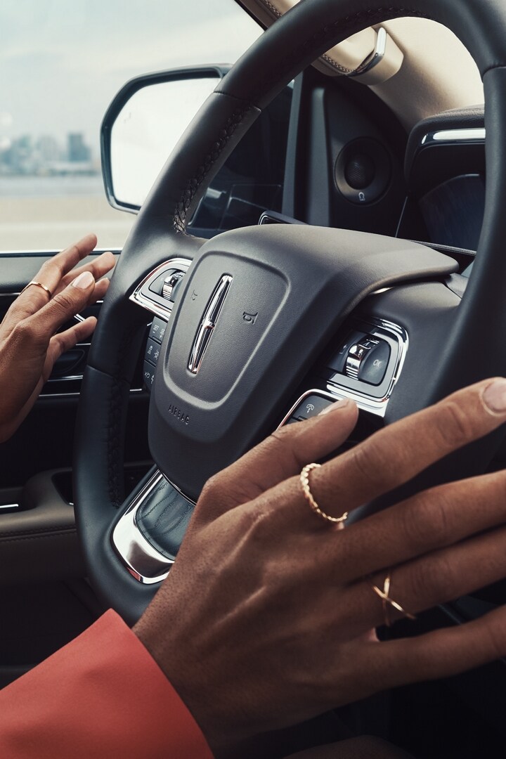 A woman uses her available Lincoln BlueCruise to operate her Navigator® hands-free while still keeping her eyes on the road