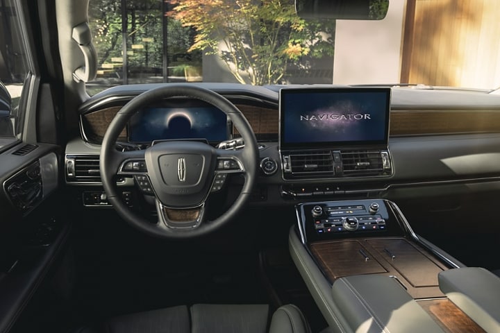 The driver’s seat and controls inside a 2024 Lincoln Navigator® SUV show off the SYNC® 4 interface across the screens.