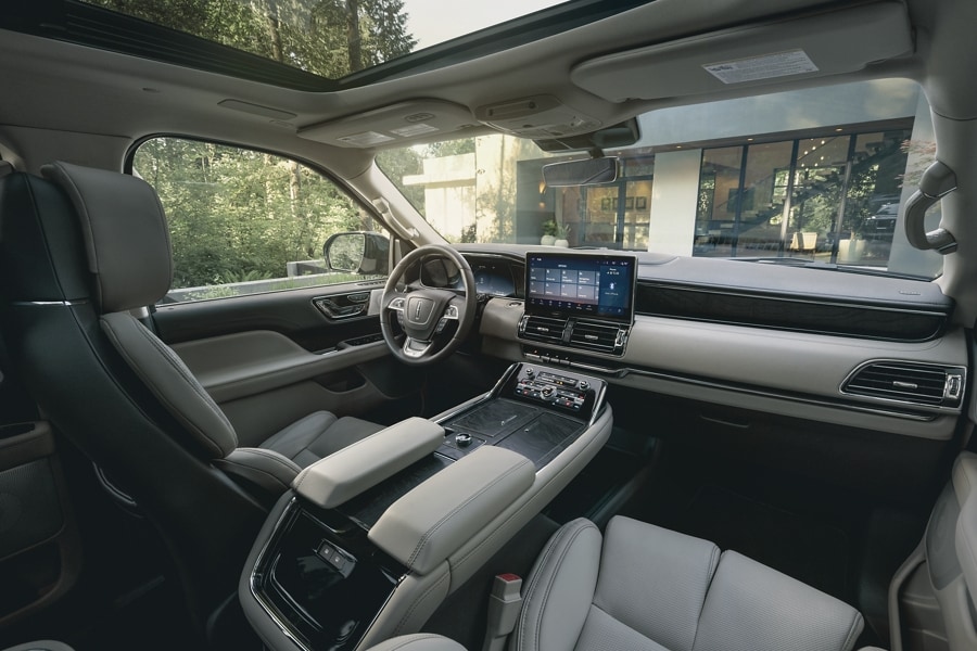 The front cabin inside a 2024 Lincoln Navigator® SUV features leather seating surfaces for a comfortable drive.