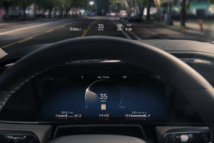 La pantalla de visualización frontal proyecta información para el conductor sobre el volante por la noche.