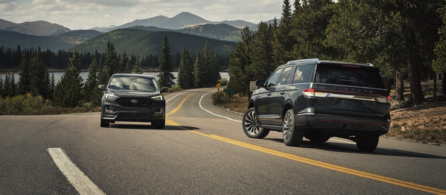 Una SUV Lincoln Navigator® 2024 gira a la izquierda cuando otro vehículo se acerca desde el otro carril.