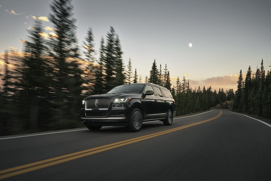 A 2024 Lincoln Navigator® SUV is being driven along a mountain road.