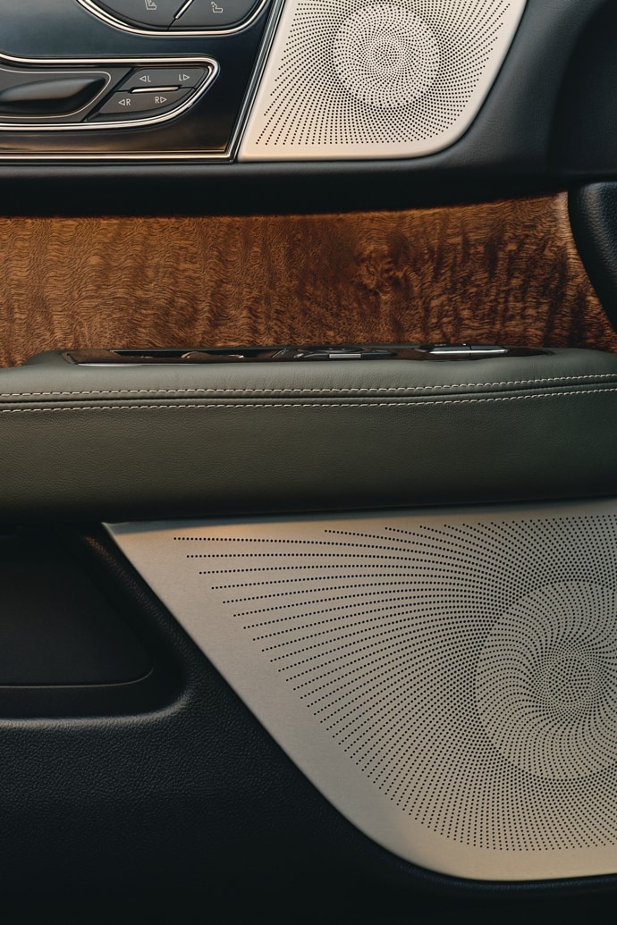 The inner door panel of a 2024 Lincoln Black Label Navigator® SUV shows the Revel® speaker design
