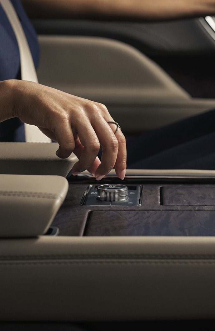 A hand is about to turn the Lincoln Drive Modes knob in the center console