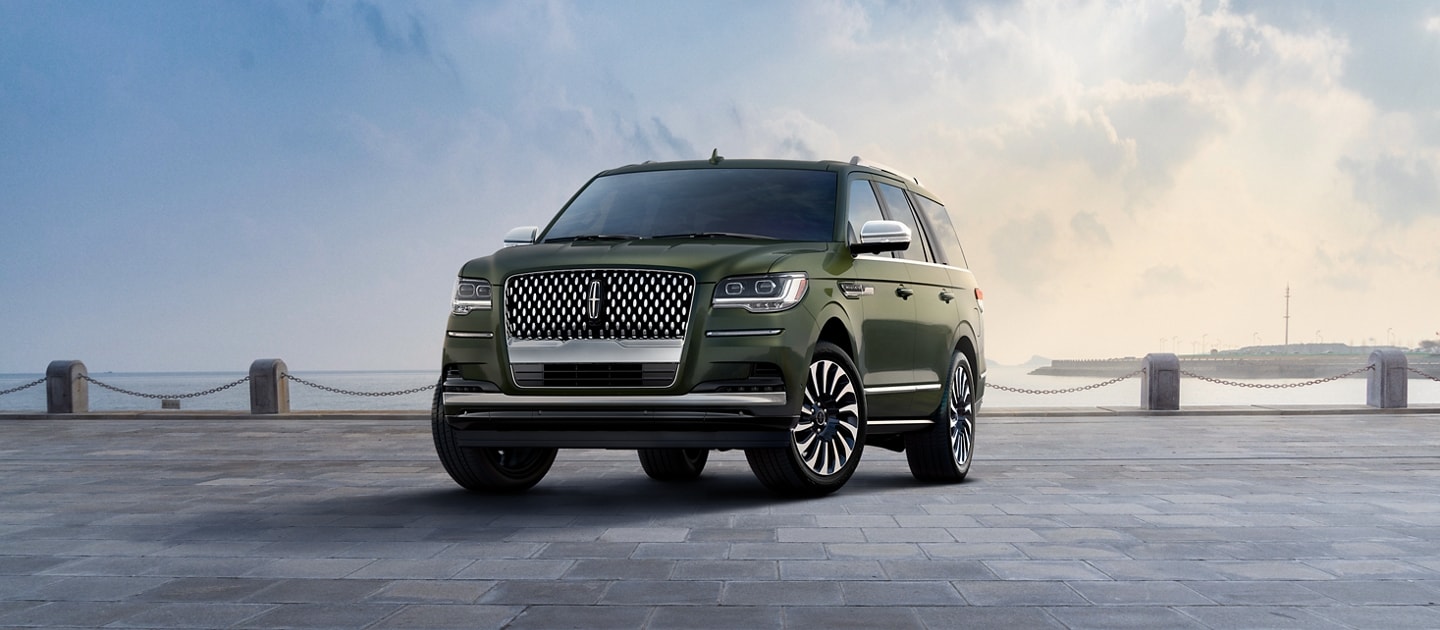 Una SUV Lincoln Black Label Navigator® 2024 en verde Manhattan​​​​​​​ estacionada en una bahía