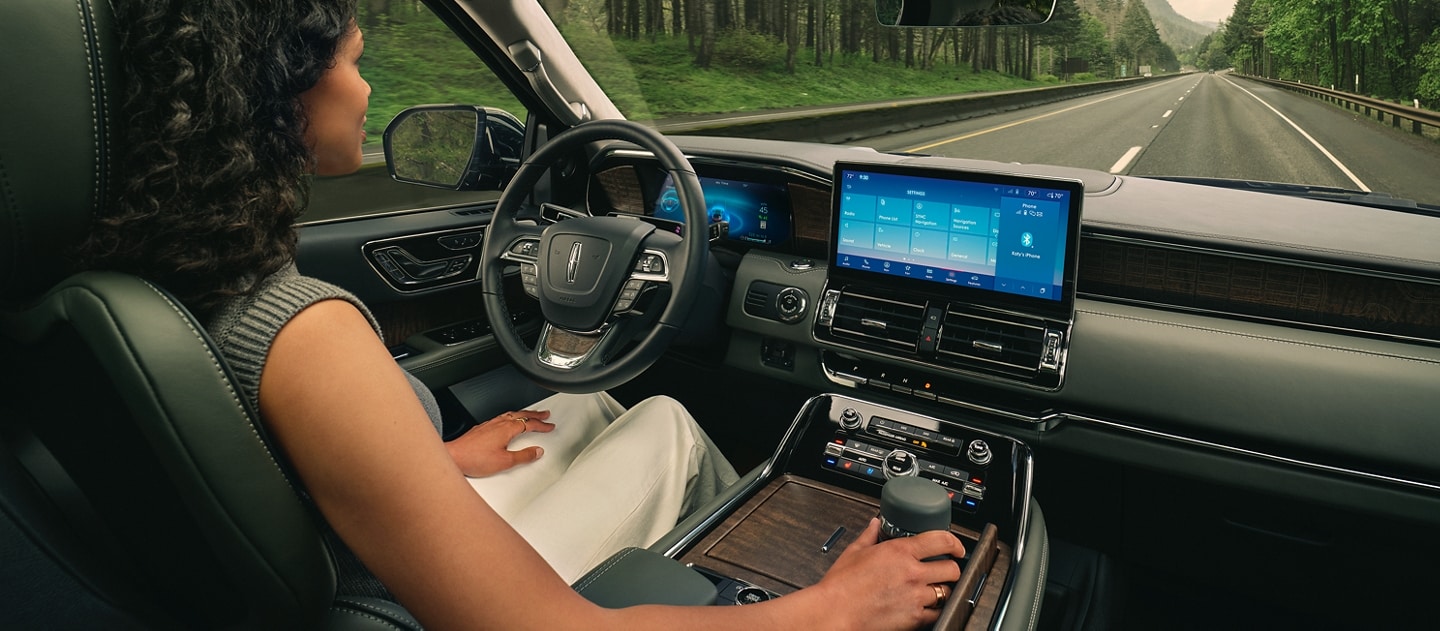 El conductor de una SUV Lincoln Black Label Navigator® 2024 se relaja con la tecnología de manejo manos libres activada.