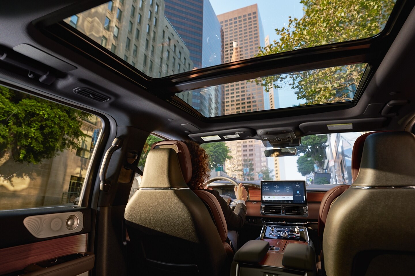Blue skies are seen through the expansive panoramic Vista Roof® as sunlight illuminates the broad cabin with a warm glow.