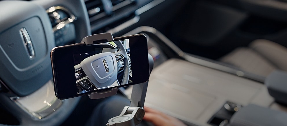 A mobile phone is shown being used to give a private remote showing of a Lincoln Black Label vehicle.