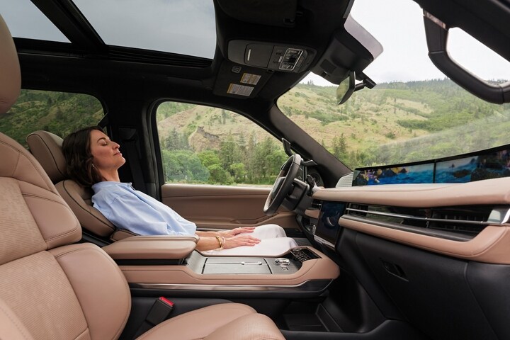 A woman enjoys the Lincoln Rejuvenate experience while seated in a parked 2025 Lincoln Navigator® SUV