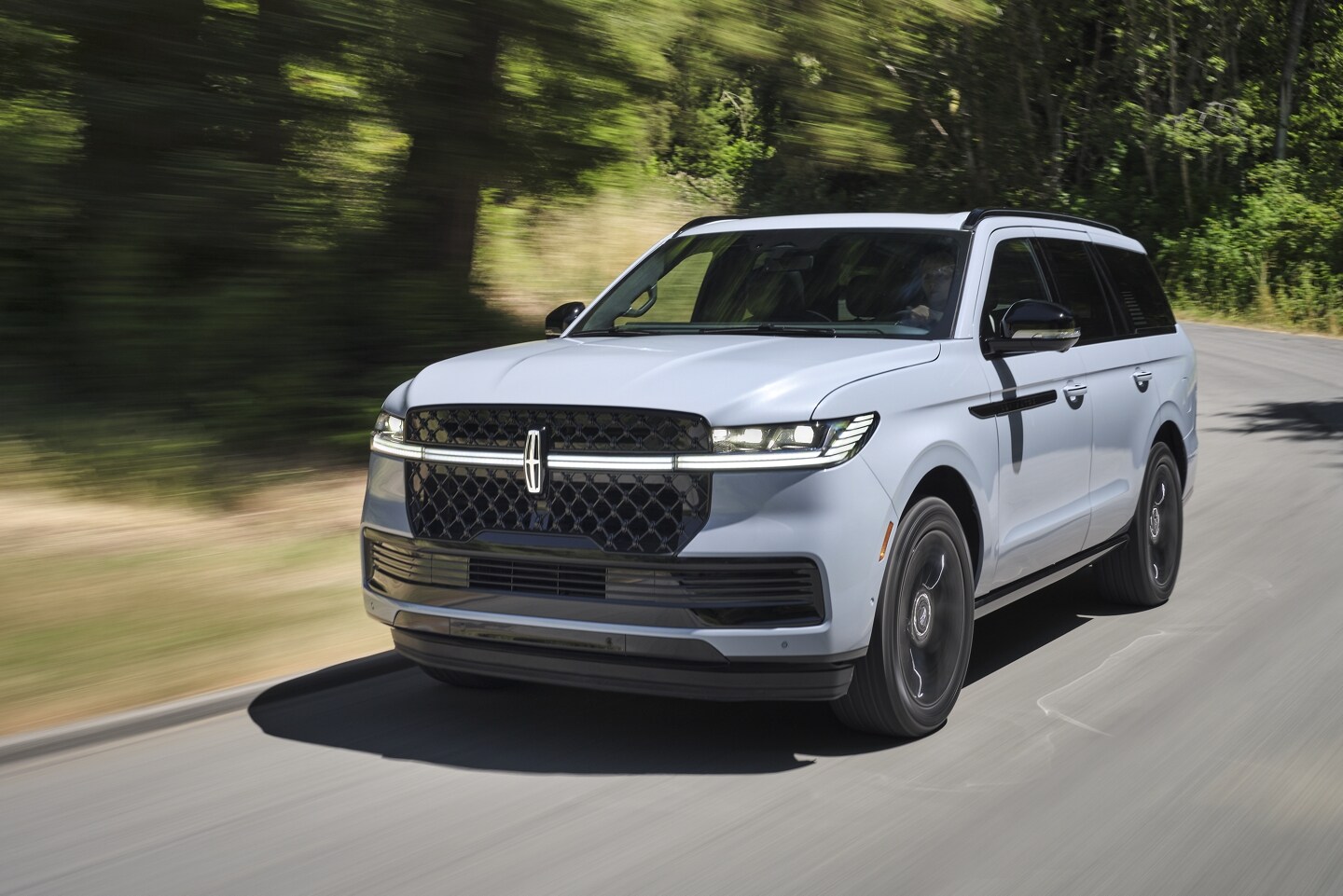 2025 Lincoln Navigator® SUV is being driven on a country road