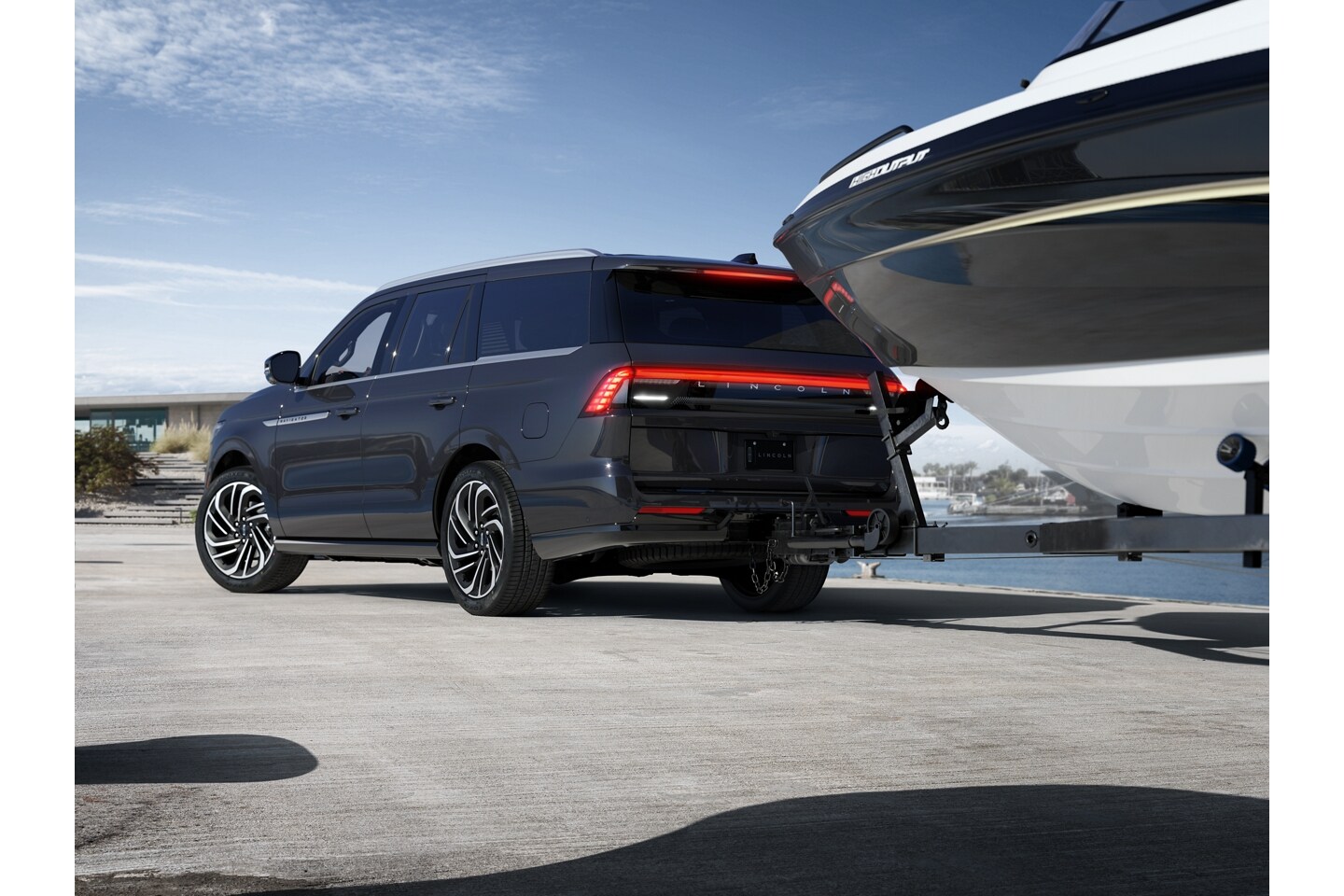 A 2025 Lincoln Navigator® SUV uses reverse trailer  Pro Trailer Backup Assist™ to guide a boat in a marina setting.