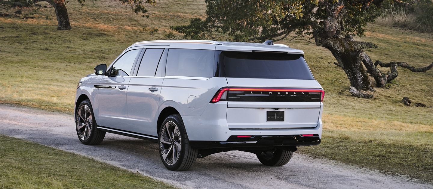 A 2025 Lincoln Black Label Navigator® SUV is being driven on a country road